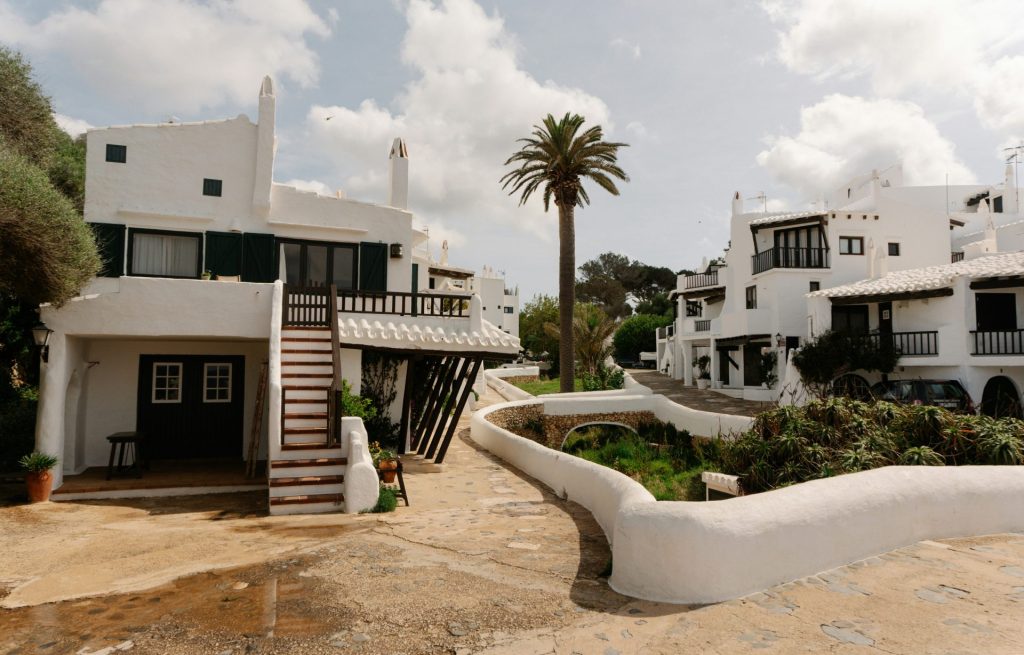 White buildings line a charming, sunny street.